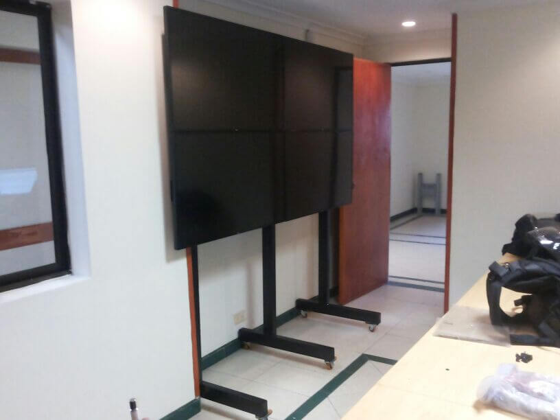 Soporte de piso movil para 4 televisores anclados a la pared Soporte de piso movil para 4 televisores anclados a la pared